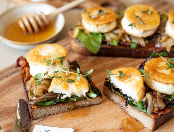 Geröstetes Sauerteigbrot mit Bacon, karamellisierten Zwiebeln und gebratenen Ziegenkäse-Talern