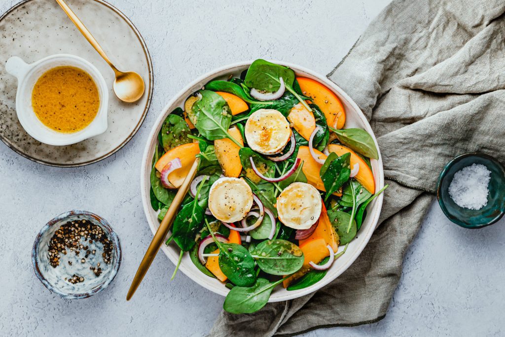 Spinatsalat mit Kaki & karamellisierter Ziegenkäserolle